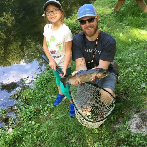 My son-in-law Andy with his daughter Eva holding a trout they just netted.