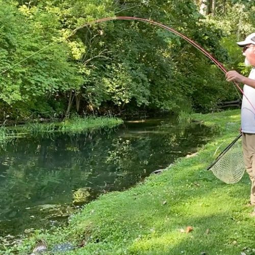 My nine year old granddaughter and I fighting a trout with her pink fly rod.