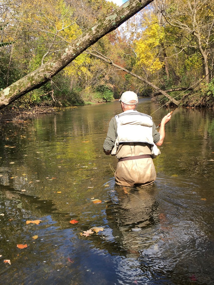 Buck wading in the Mad River casting to a fish.