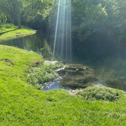 Concentrated light rays coming from the sky and bouncing off the water