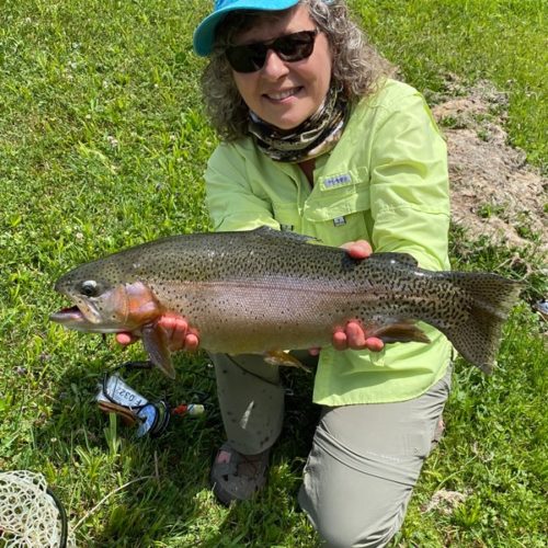 My wife, Mel, crouched down holding her rainbow trout