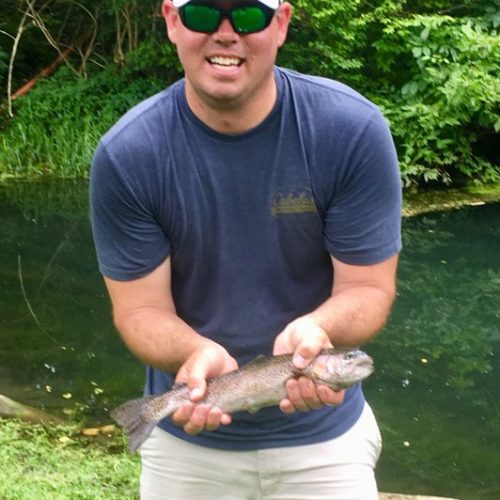 A young male holding his first rainbow trout he caught