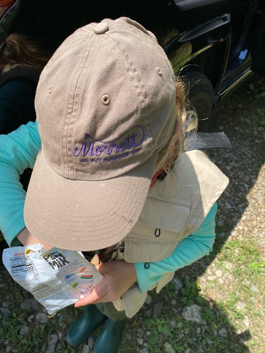 Shot from above Eva's head with her head down to see the Morrett Fly Fishing logo on her hat.