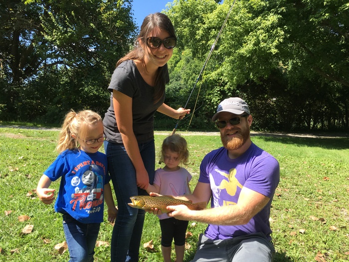 Eva, Sarah, Lila and Andy posing for picture with a family caught trout.