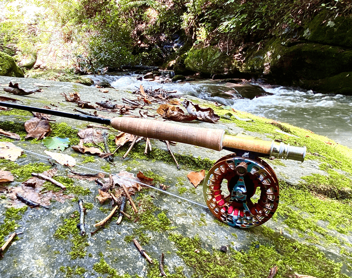 A Winston rod with an Abel reel sitting on a rock