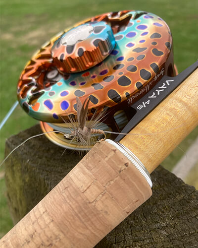 A close-up of an Abel reel with a Hendrickson Thorax Dun fly.