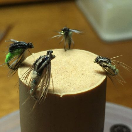 Four CDC caddis larvae hooked into a cork